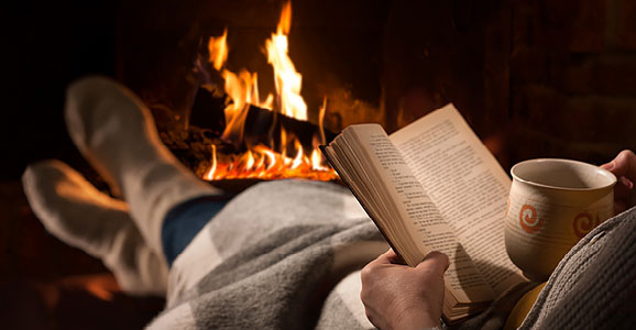 Vor dem Kaminfeuer ein Buch lesen