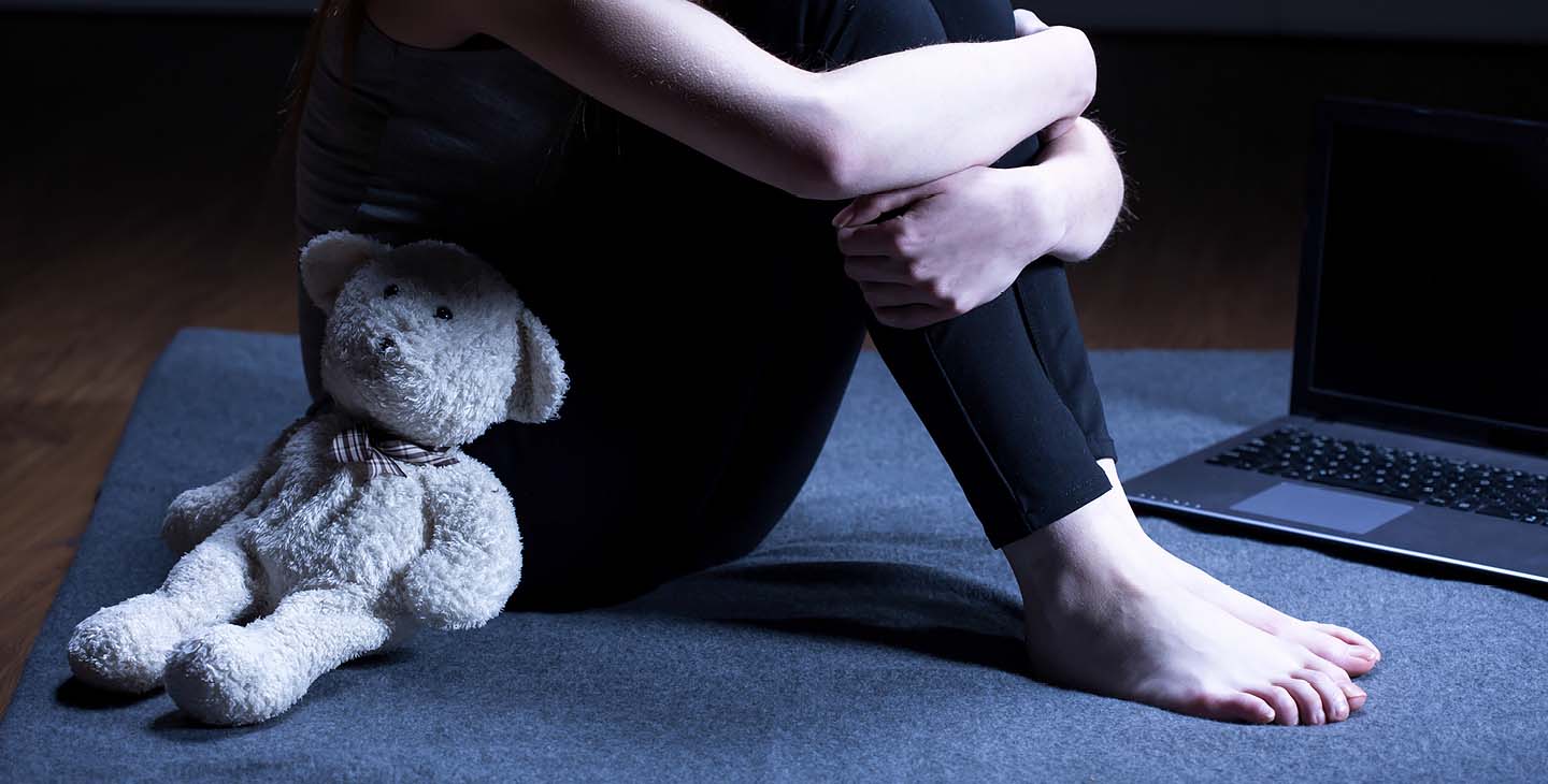 Teddybär lehnt an Frau mit schwarzer Leggins
