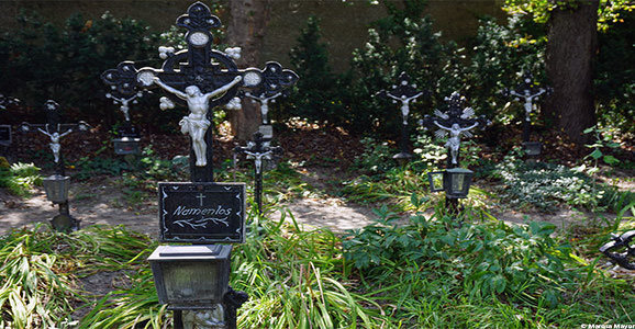 Grabkreuze mit Jesus auf einem Friedhof im Wald