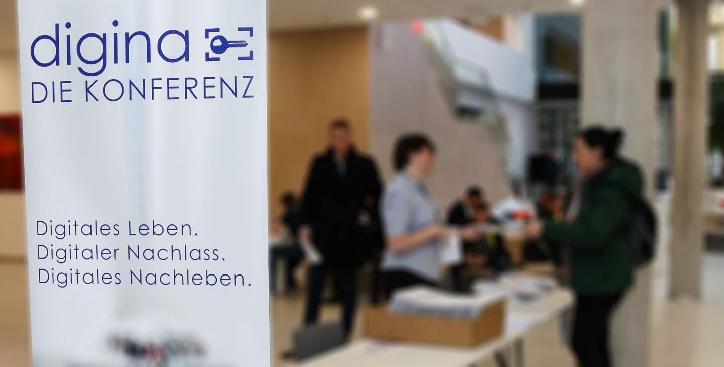 Im Vordergrund ein Poster von digina die Konferenz und im Hintergrund sind Menschen