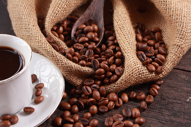 Tasse mit Kaffee und daneben ein Sack mit Kaffeebohnen