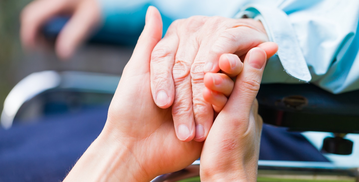Junge Frau hält die Hand einer älteren Frau