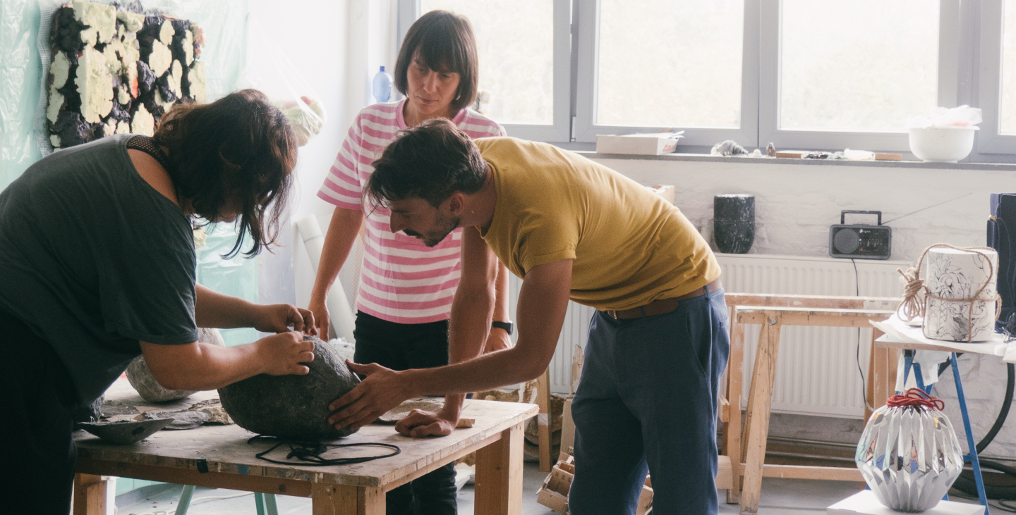 Drei Künstler arbeiten in einer Werkstatt