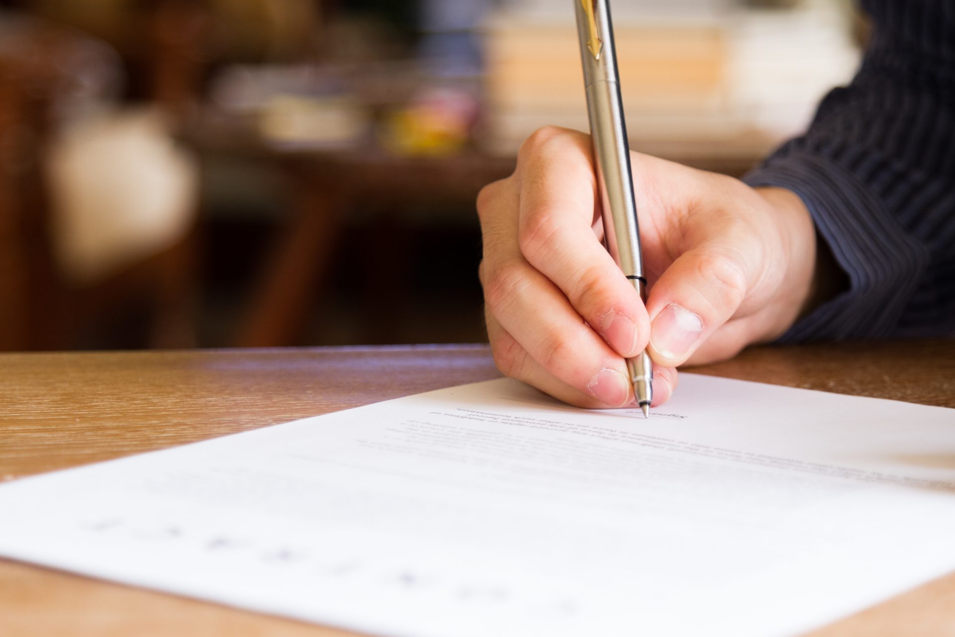 Mann mit Stift in der Hand unterschreibt einen Vertrag
