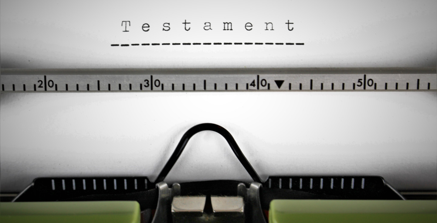 Ein Bild einer Schreibmaschine mit einem Blatt wo drauf steht Testament