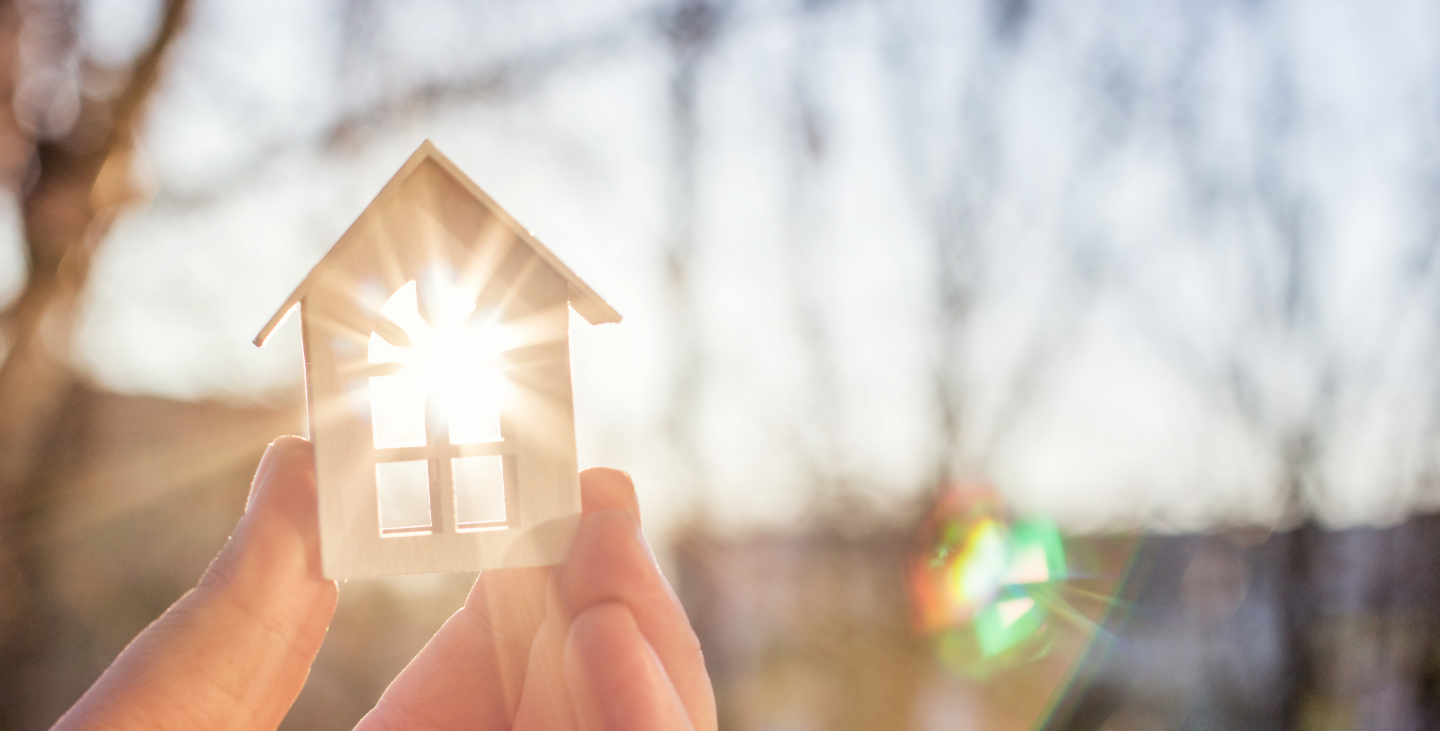 Modellhaus in der Hand im Sonnenlicht