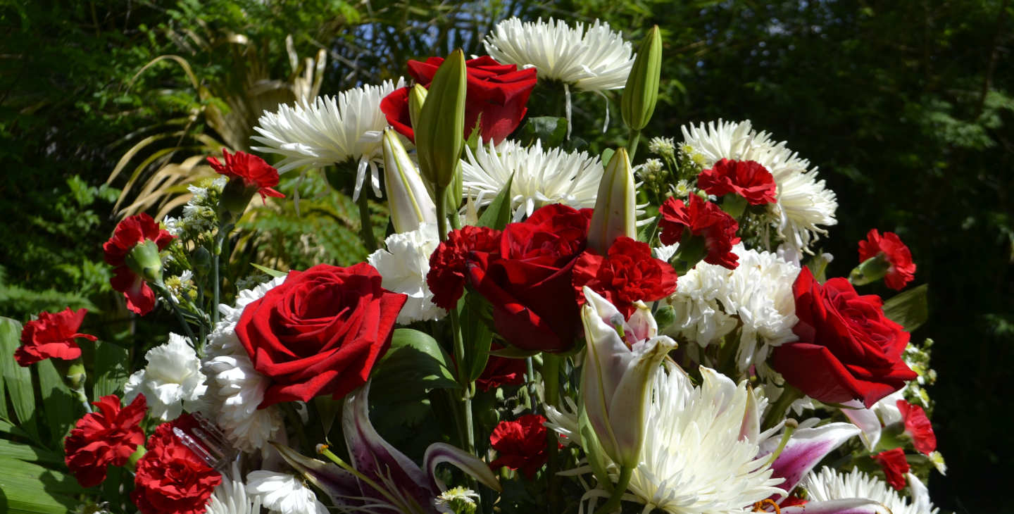 Weiße Blumen und rote Rosen in einem Blumenstrauß