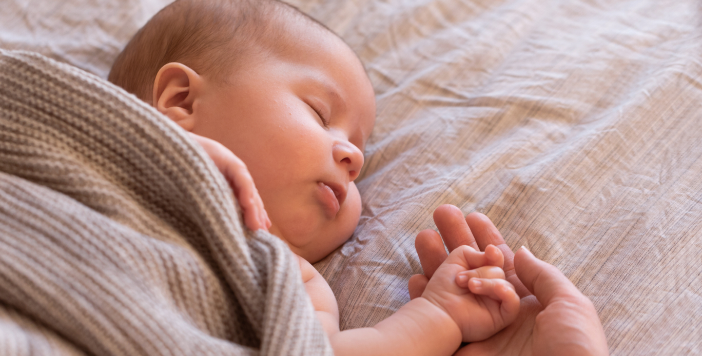 Baby schläft friedlich und hält Händchen