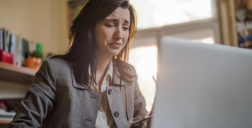 Frau sitzt weinend vor dem Laptop