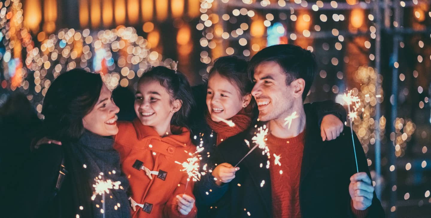 Familie mit kleinen Kindern mit Wunderkerzen