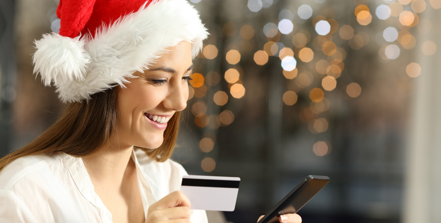 Frau mit Weihnachtsmütze und Kreditkarte