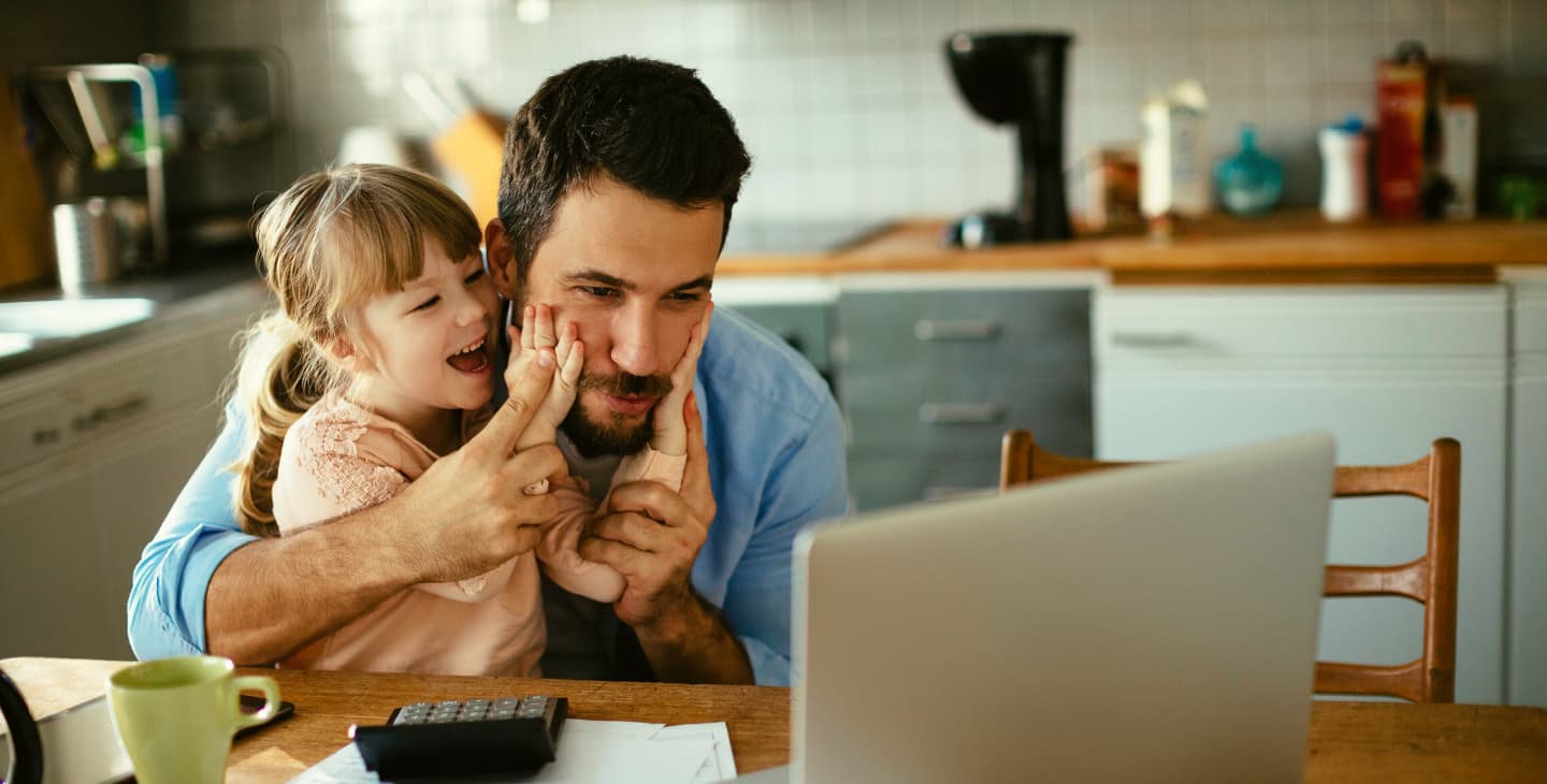 Papa mit kleiner Tochter im Homeoffice