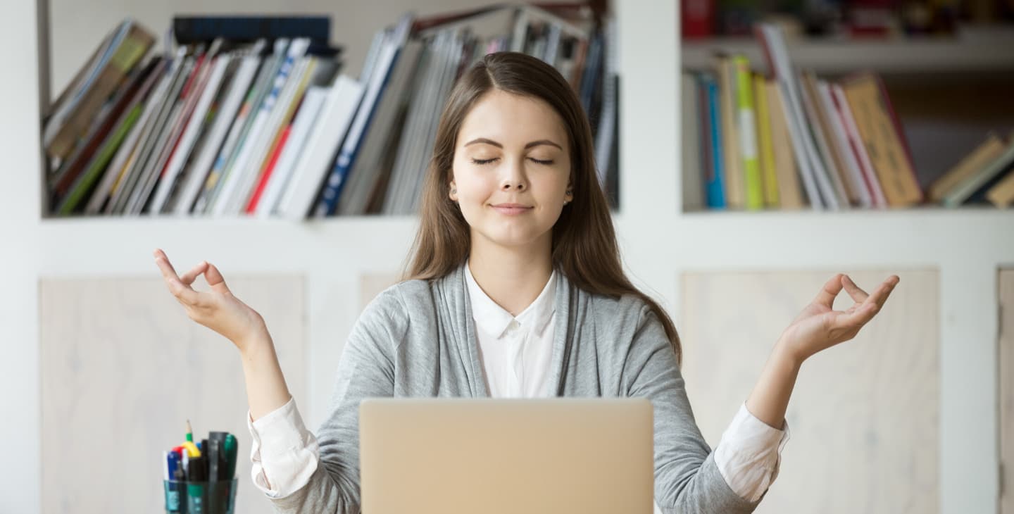Frau macht Yoga vor dem Laptop