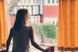 Frau schaut aus dem Fenster