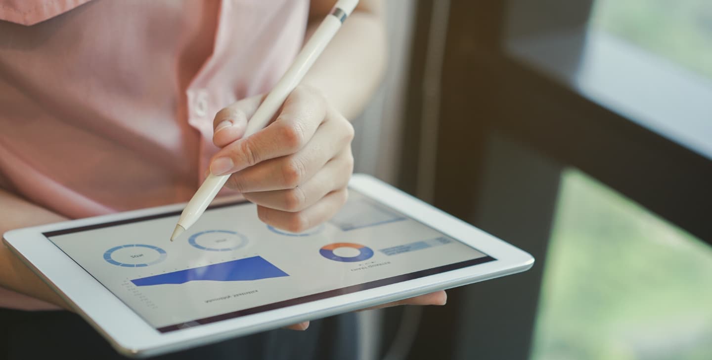 Frauenhand mit Pencil betrachtet Charts auf einem Ipad