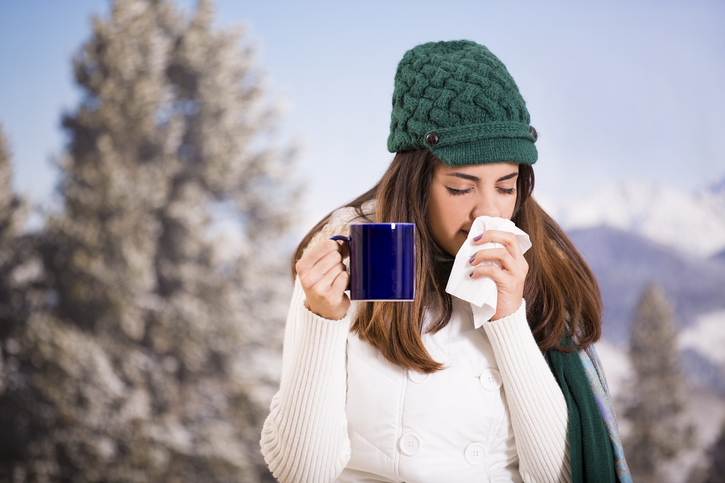 junge Frau mit Tasse und Schnupfen