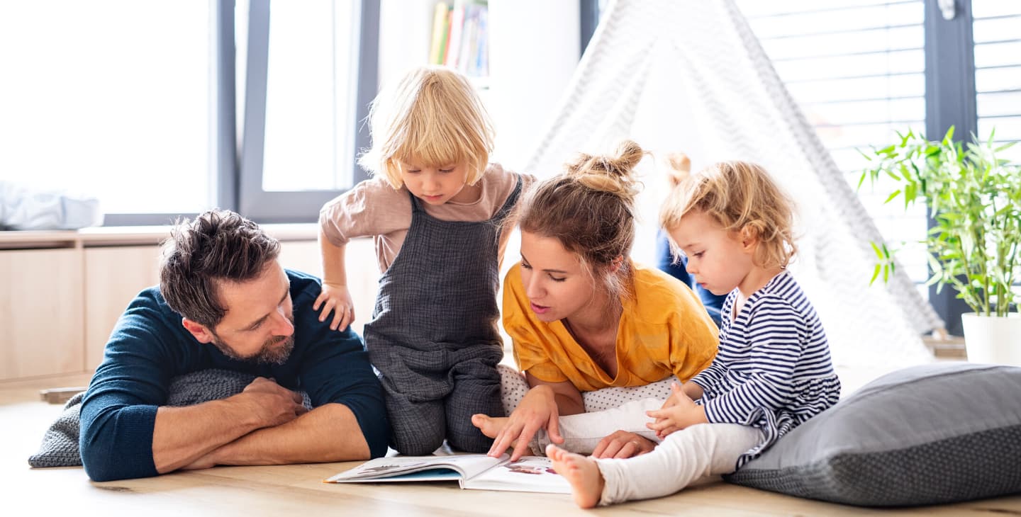 Mutter liest ihren beiden Kindern aus Buch vor
