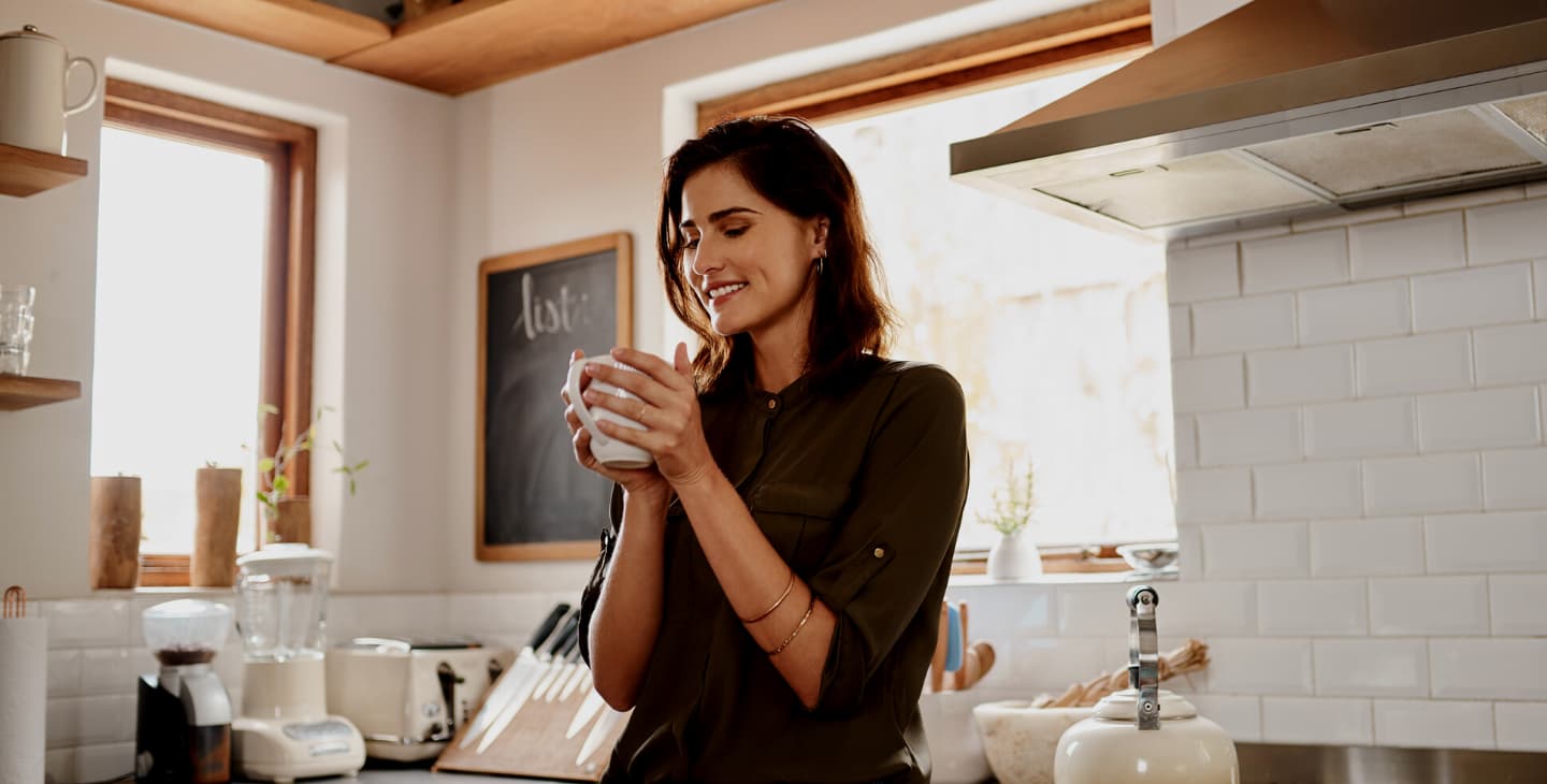 Frau hält eine Tasse Kaffee fest in der Hand