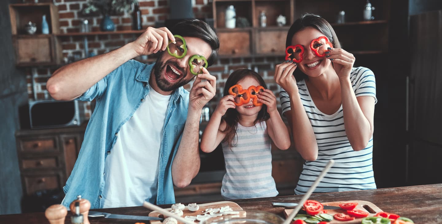 Familie mit geschnittenen Paprika als Brille