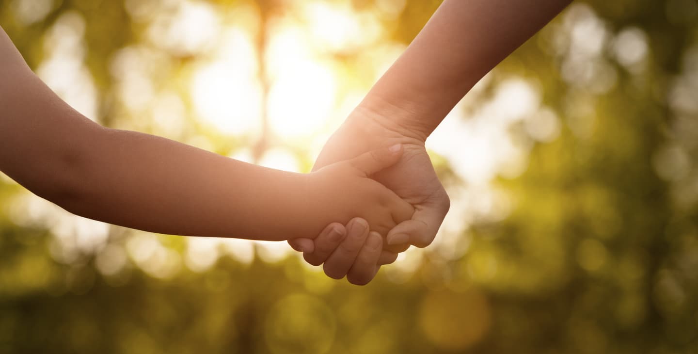 Kinderhand hält andere Hand