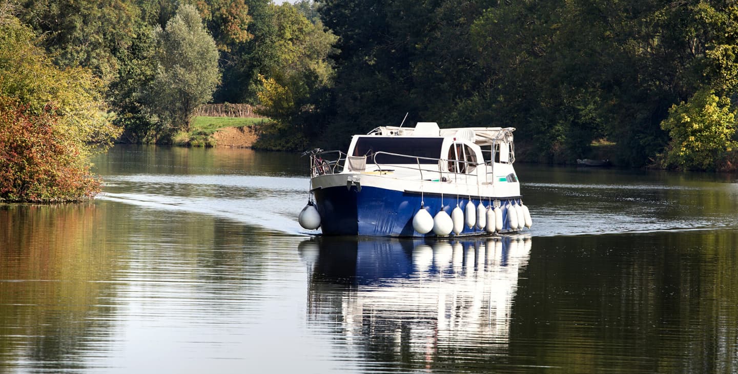 Ein Hausboot fährt auf dem Fluss entlang