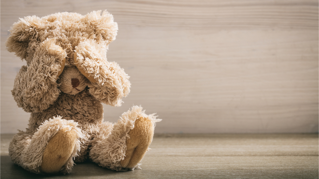 Stoffteddy hält sich die Augen zu