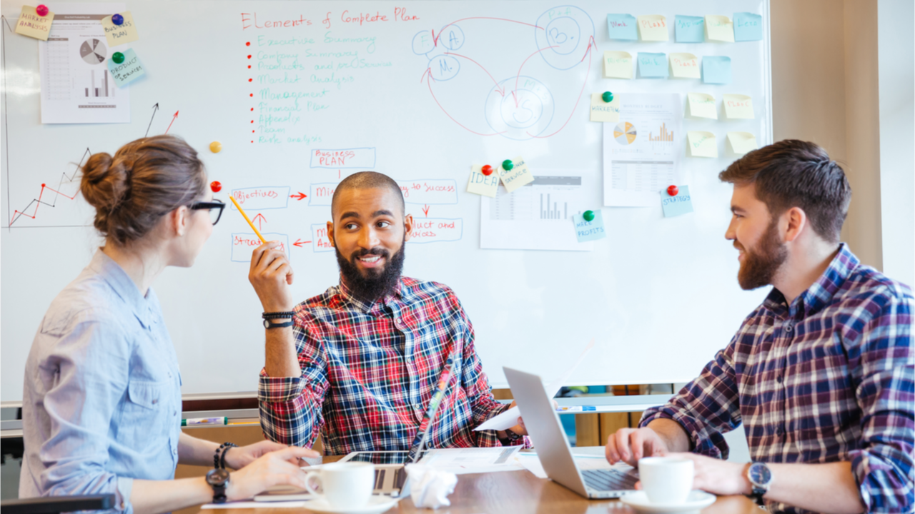 3 junge Leute machen ein Brainstorming mit Laptop und Post Its