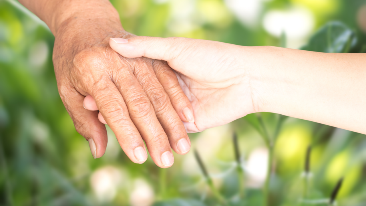 junge und alte Hand halten sich