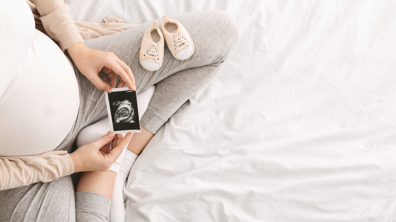 schwangere Frau betrachtet Ultraschallbild des Babys