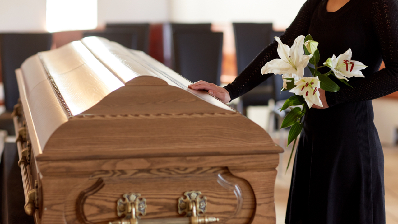 Sarg mit Frau in schwarzem Kleid und Blumen