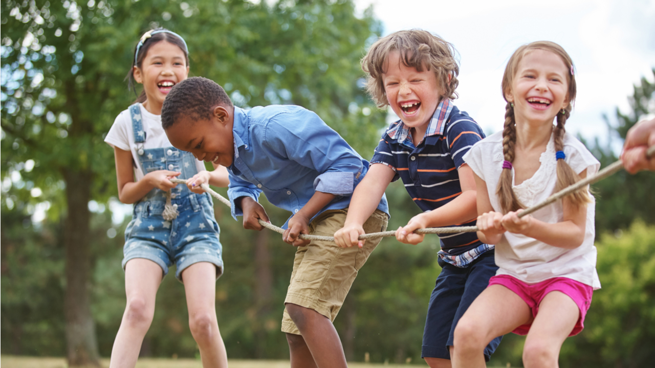 vier kleine Kinder ziehen an einem Seil