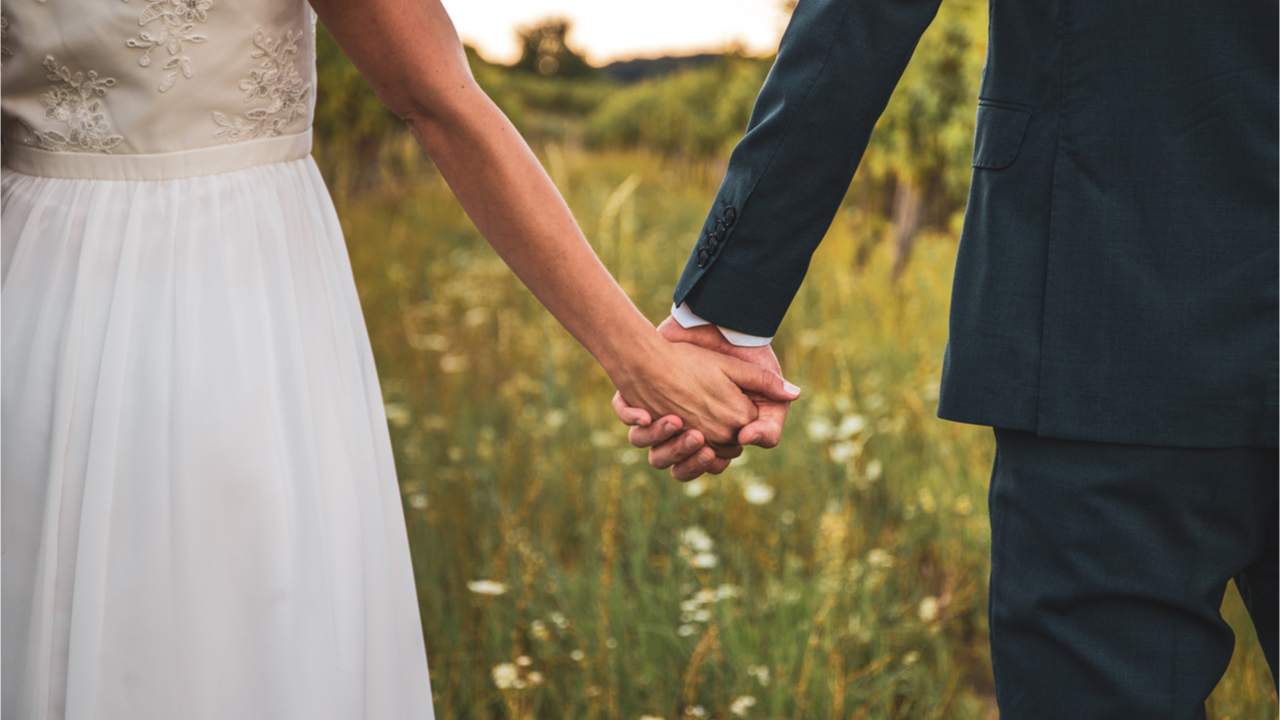 Hochzeitspaar geht Hand in Hand