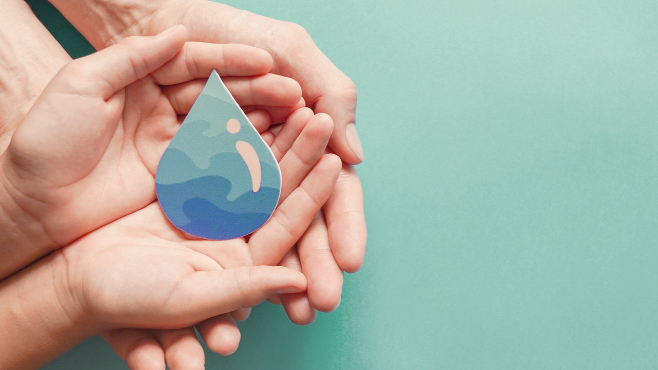 Kind hält einen Wassertropfen aus Karton in den Händen
