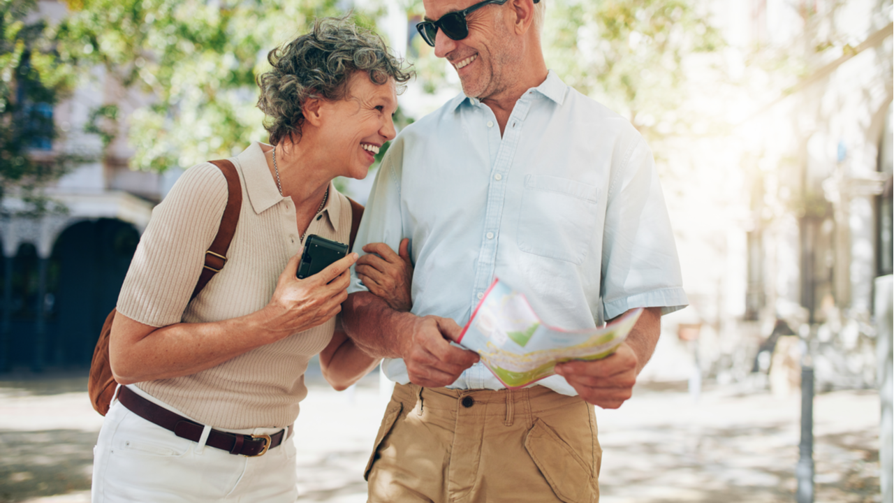 Rentnerpärchen mit Stadtplan und Smartphone