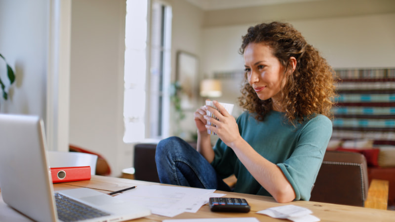 Frau sitzt vor Laptop und macht eine Finanzplanung