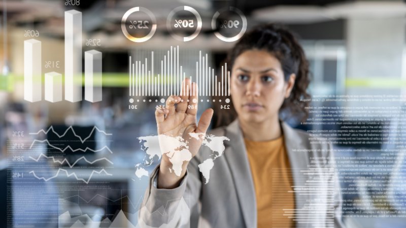 Frau vor Diagrammen an Touch-Monitor