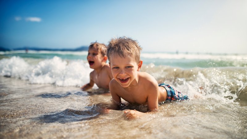 zwei kleine Kinder am Strand in den Wellen