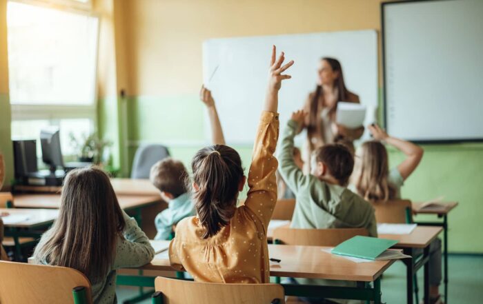 Grundschüler melden sich im Unterricht