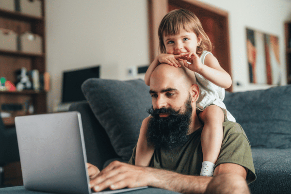 Vater und Tochter sitzen gemeinsam am Laptop