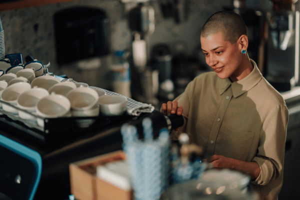 Barista im Minijob bereitet Kaffee zu