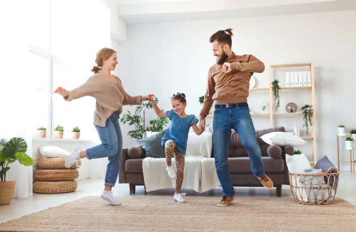 Paten tanzen im Wohnzimmer mit Patenkind