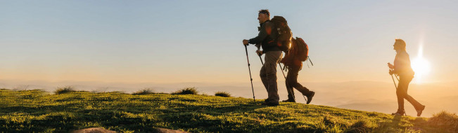 Drei Wanderer auf dem Weg zum Gipfel im Sonnenaufgang