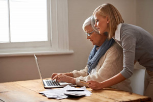 Tochter und Rentnerin arbeiten gemeinsam am Laptop